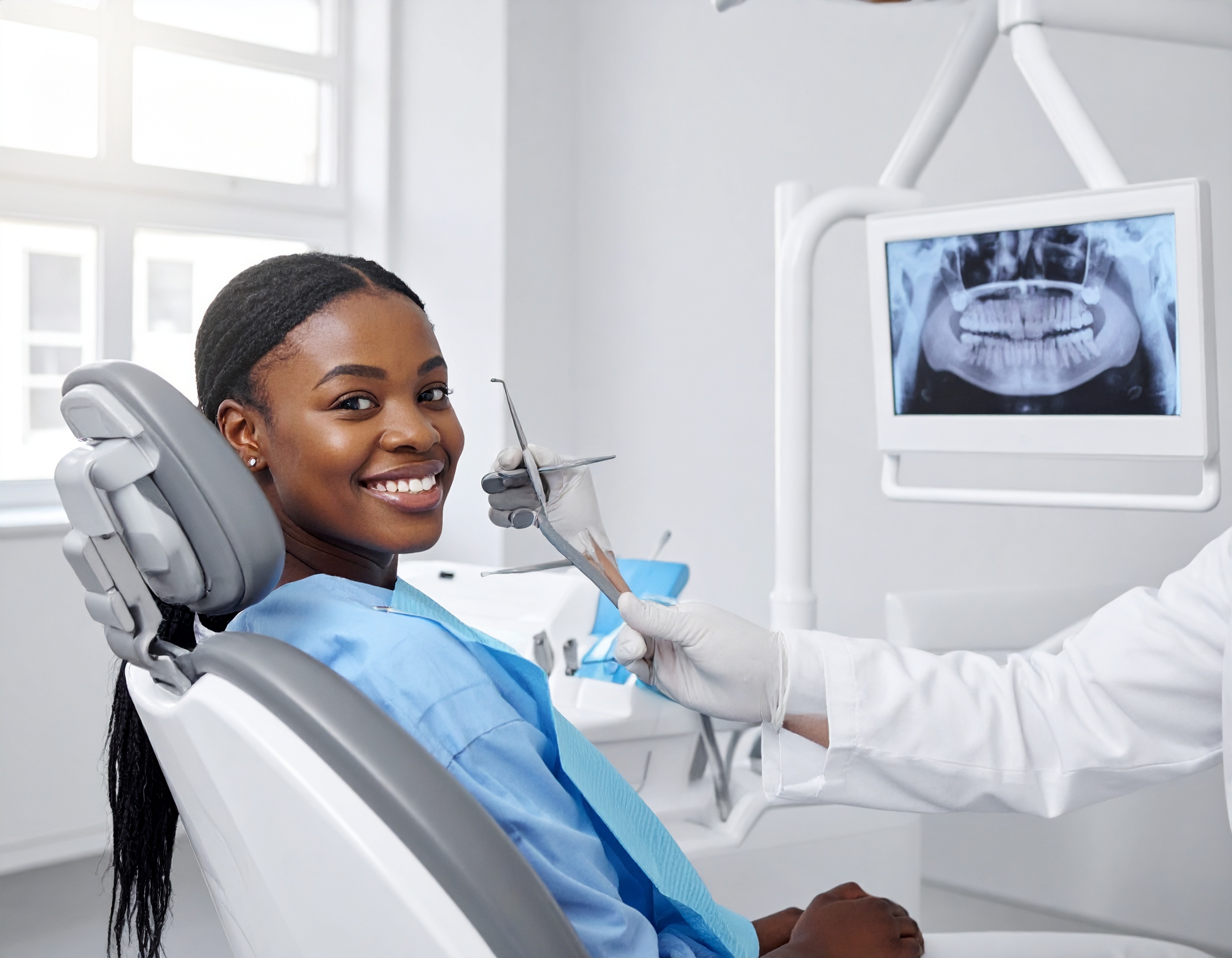 Young dental patient smiling during a youth dental care checkup with digital x-ray review